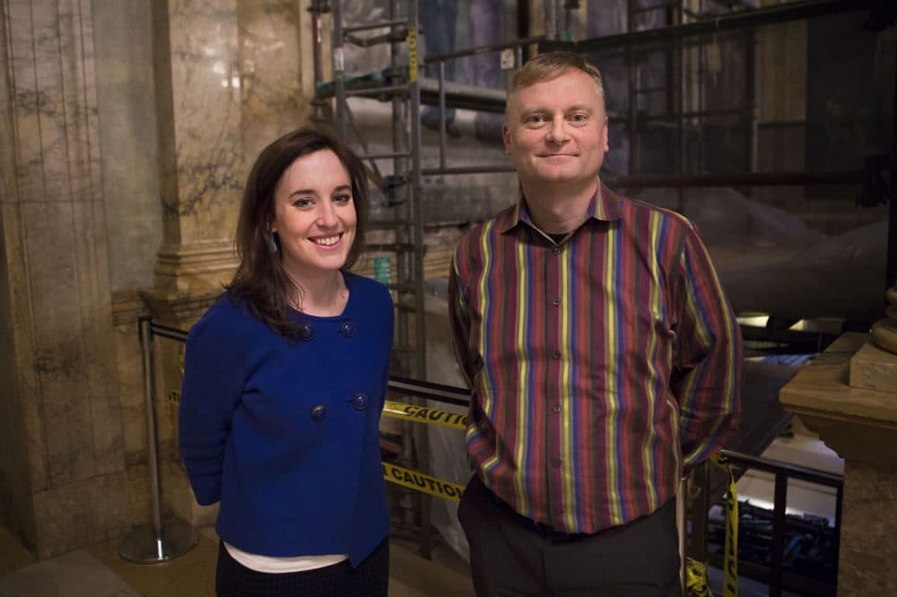 Exhibitions and outreach associate Meghan Weeks and interim President David Leonard stand in the grand staircase at the BPL. (Jesse Costa/WBUR)