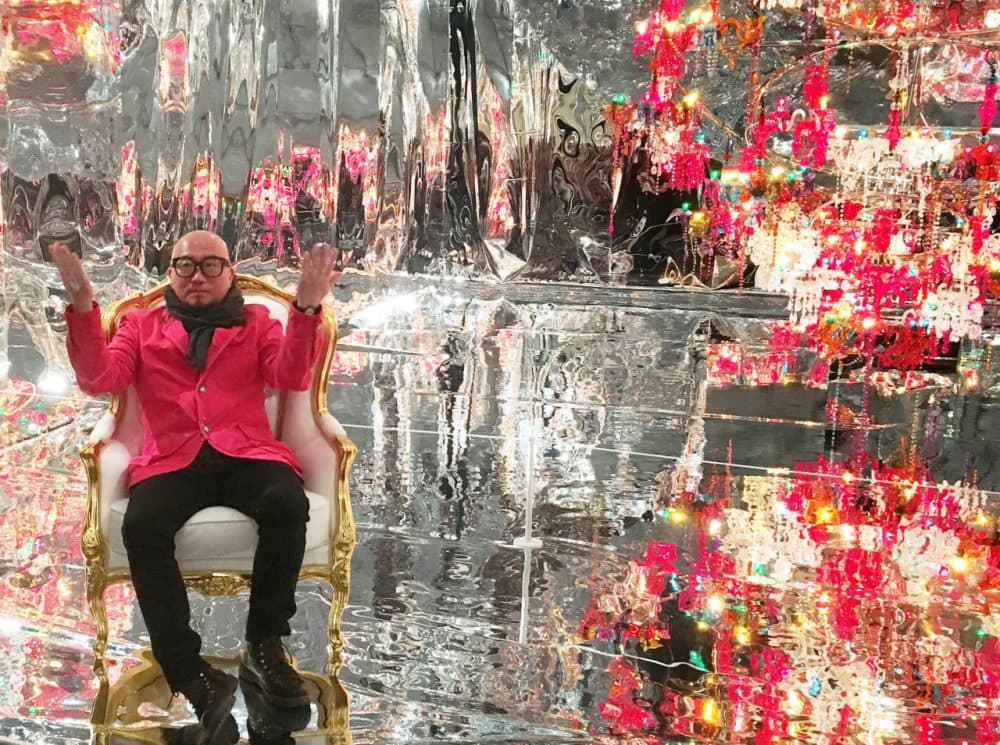 Choi Jeong Hwa sits in his "Chaosmos Mandala" at the MFA that invites visitors to pull up a chair and share photos on social media to become part of the art. (Andrea Shea/WBUR)