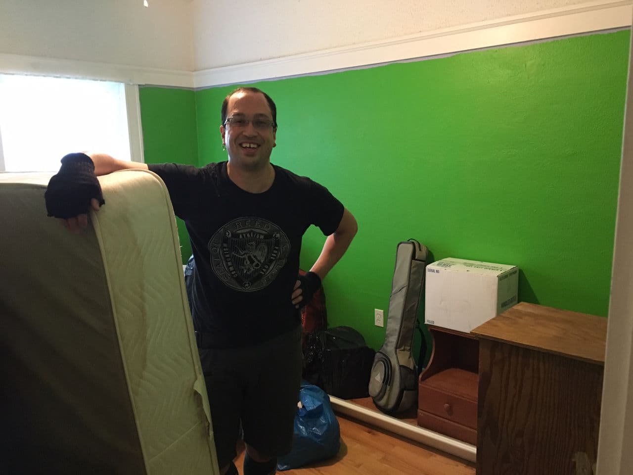 Nate Martin in his new room, after cyclists transported his belongings to his apartment. (Jill Ryan/Here & Now)
