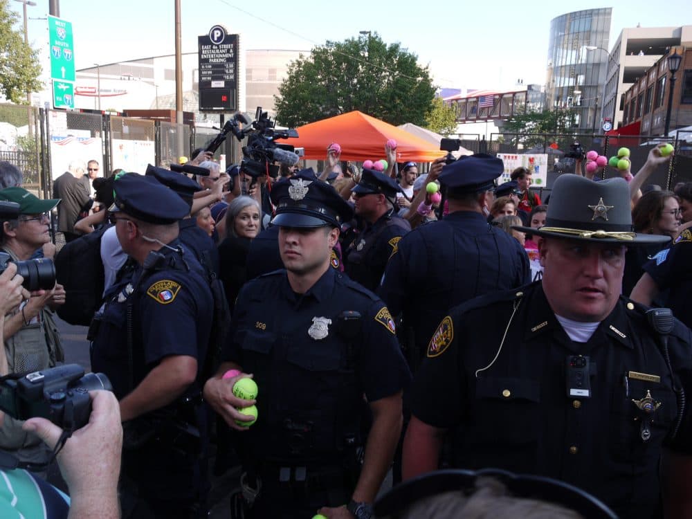 On Tuesday night near Quicken Loans Arena, police confiscated tennis balls that were tossed onto the street by protesters chanting "ban assault weapons, not tennis balls." The demonstrators were speaking out against the security rules for the Republican National Convention, which prohibit tennis balls and other items that authorities says could be used as weapons. Under Open Carry, Ohioans are allowed to carry weapons in public. (Alex Ashlock/Here & Now)