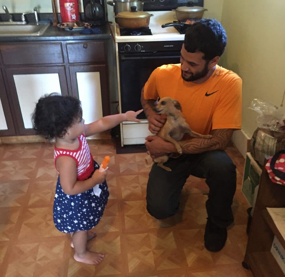 Juan Rivera plays with his daughter Zahira in the kitchen of their Cleveland home. (Robin Young/Here & Now)