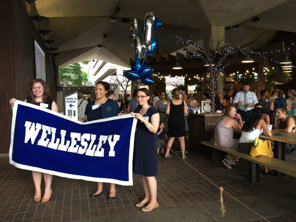 Women at the Philadelphia Wellesley College Club hold up a sign at a celebration for Hillary Clinton's nomination. (Samantha Fields/Here & Now)