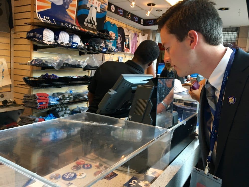 Trevor Doiron checks out swag inside the Wells Fargo Center. (Shannon Dooling/WBUR)