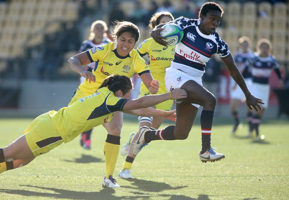 Victoria Folayan, in the red, white and blue uniform, jumps through the tackle of Australia's Sharni Williams, left, in a women's Sevens World Series rugby game at Kennesaw State University in 2014. (Jason Getz/AP)