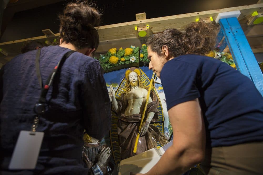 MFA objects conservator Abigail Hykin and Brooklyn Museum conservator Lisa Bruno examine Giovanni della Robbia's "The Resurrection of Christ" after it was uncrated in the exhibition hall. (Jesse Costa/WBUR)