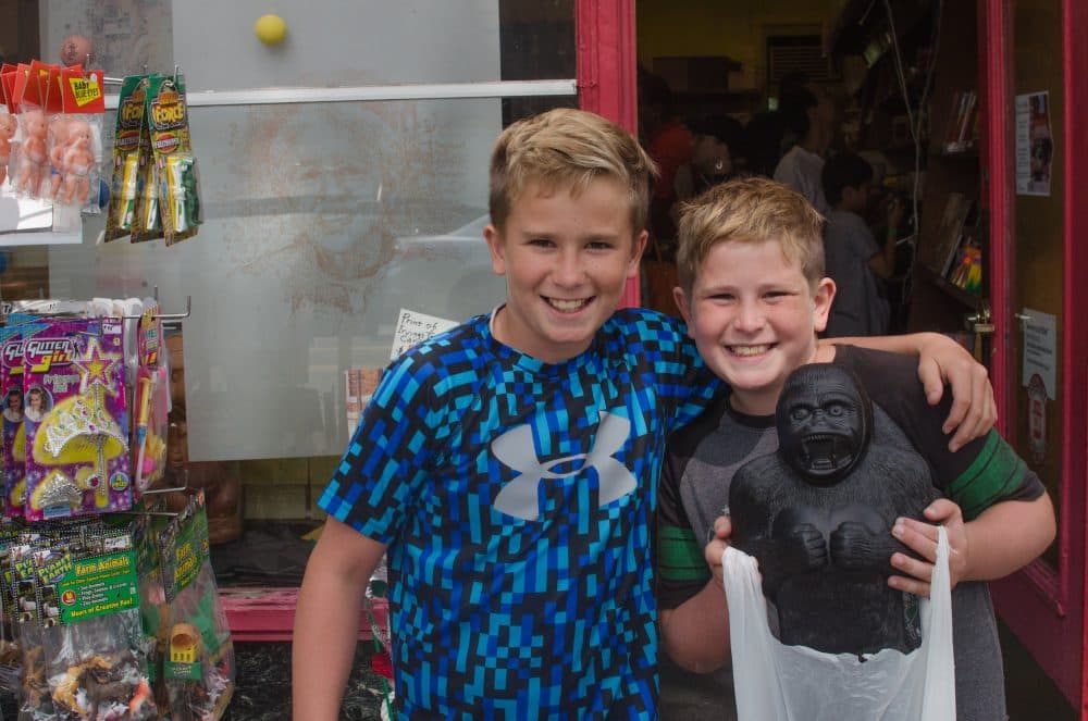 Owen and Gavin O'Connell, of Brookline, after making their final purchases of candy, toys and knickknacks at Irving's. (Sharon Brody/WBUR)