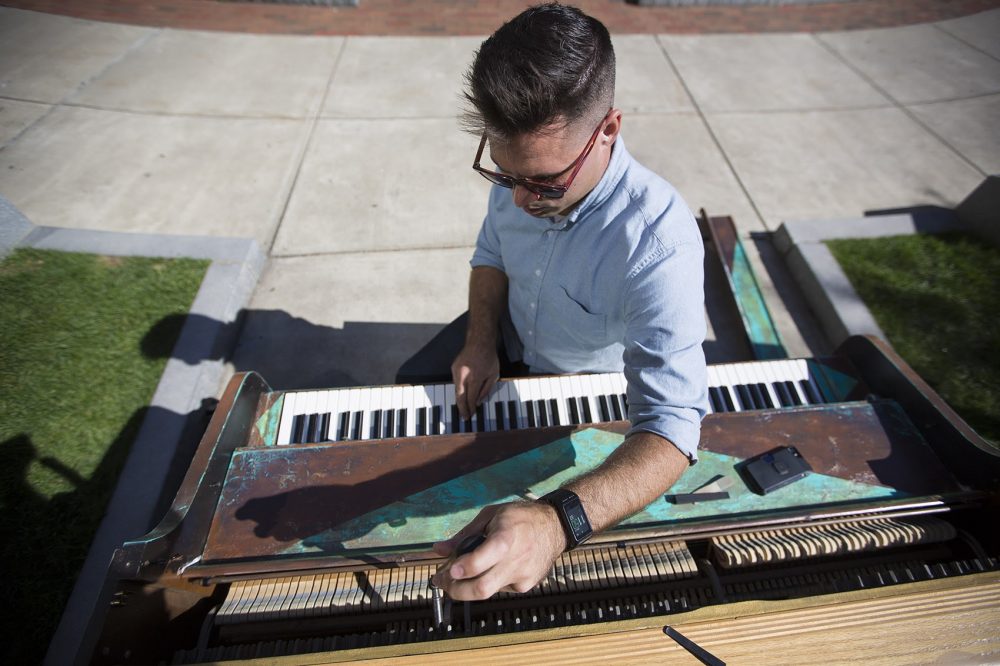 Michael Wilson at work at the piano in Boston's Statler Park. (Jesse Costa/WBUR)