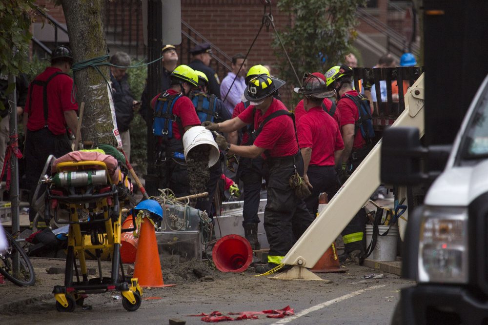 Workers clear out a trench that flooded from a water main break. (Jesse Costa/WBUR)