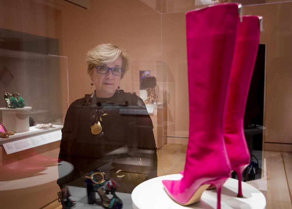 PEM deputy director and curator Lynda Roscoe Hartigan stands by a pair of Yves Saint Laurent leather boots at the "Shoes: Pleasure and Pain" exhibit. (Robin Lubbock/WBUR)