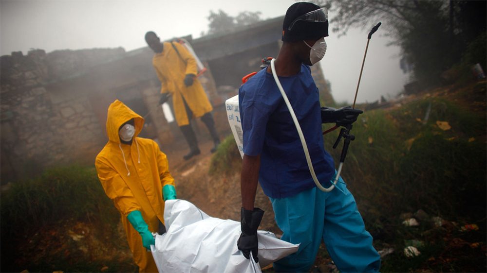 Health workers collect the body of a cholera victim in Petionville, Haiti, in February 2011. The disease first appeared on the island in October 2010. (NPR)
