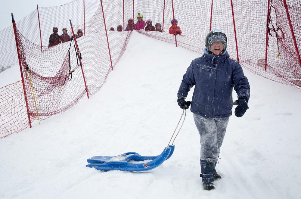 Jen Fuller, 42, enjoys her moment of triumph after completing a successful run down the luge slope. (Robin Lubbock/WBUR)