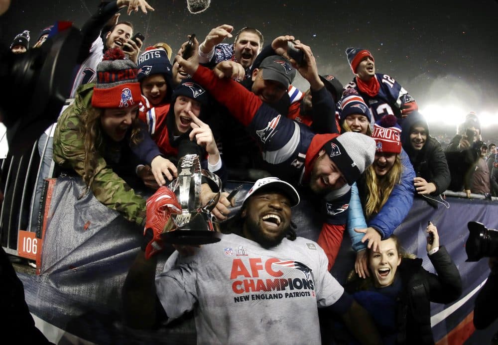 New England Patriots running back LeGarrette Blount holds the AFC championship trophy surrounded by fans after the AFC championship. (Matt Slocum/AP)