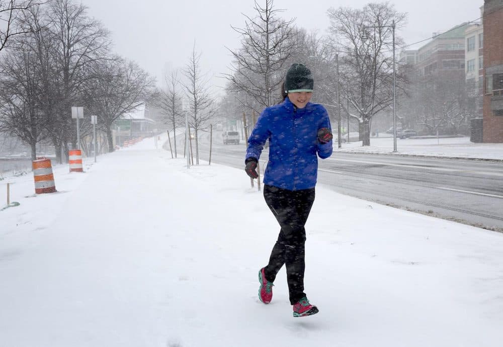 A runner braves the winter storm on Memorial Drive in Cambridge. (Robin Lubbock/WBUR)
