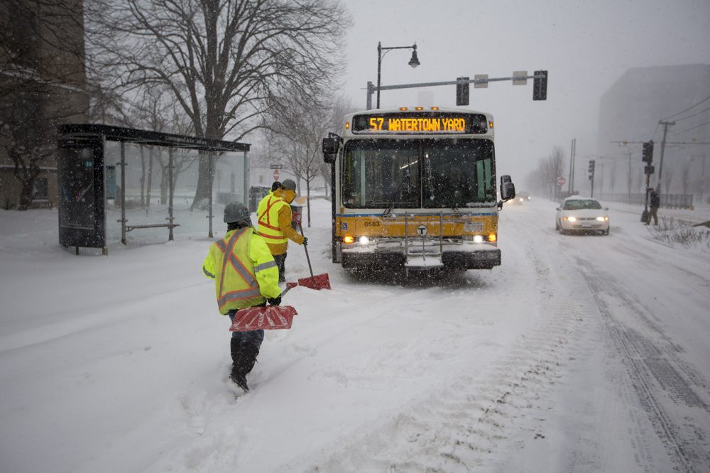 A work crew arrives to dig out an MBTA bus stuck on Commonwealth Ave. (Jesse Costa/WBUR)