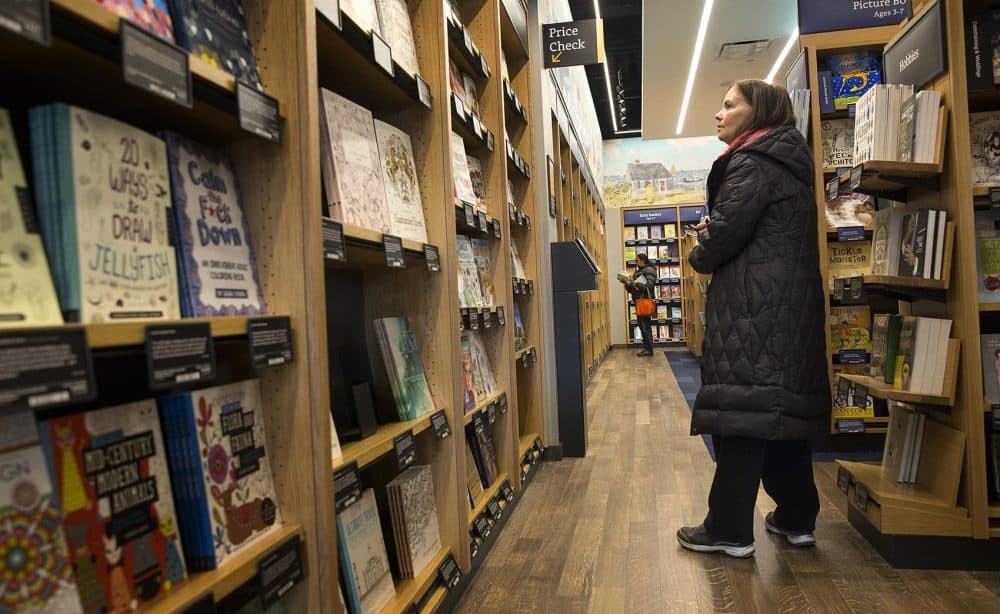 Susan Crowley, of Westwood, browsed for books at the new Amazon bookstore in Dedham. "I love books and just having Amazon here sounded so great," she said. "So I wanted to see what it's all about. And I love having it so close to home." (Robin Lubbock/WBUR)
