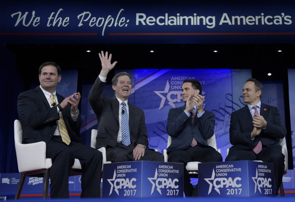 Kansas Gov. Sam Brownback, second from left, waves as he is introduced for a panel discussion at the CPAC in Oxon Hill, Md., on Thursday. From left are, Arizona Gov. Doug Ducey, Wisconsin Gov. Scott Walker and Kentucky Gov. Matt Bevin. (Susan Walsh/AP)