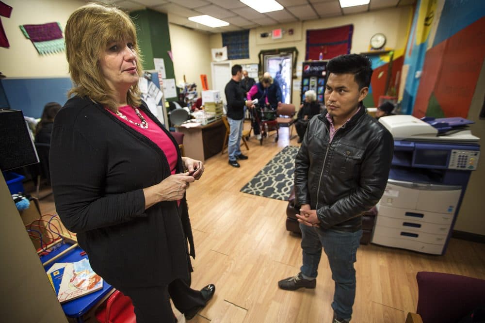 At the Community Economic Development Center in New Bedford, Corinn Williams, left, assists a community member who has come in to inquire what he can do about being harassed on Facebook. (Jesse Costa/WBUR)