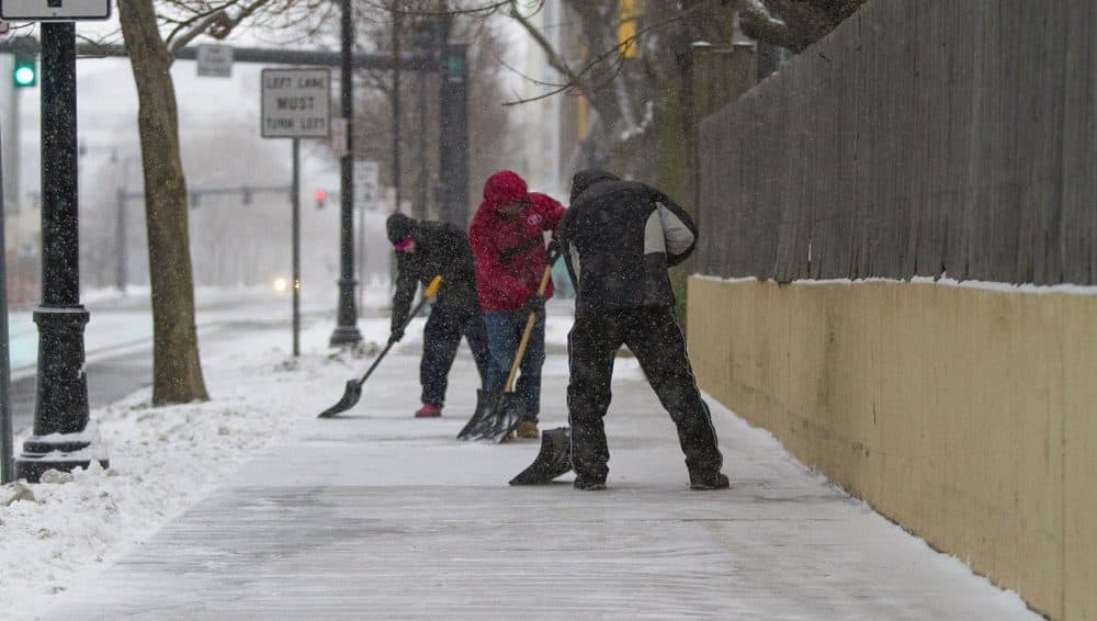 Workers cleared snow from the sidewalk on Binney Street in Kendall Square. (Jesse Costa/WBUR)