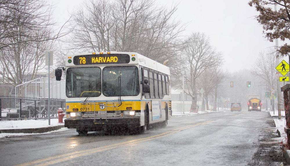 A bus made its way down a lonely Concord Avenue as snow began to fall at the start of Tuesday's storm. (Robin Lubbock/WBUR)