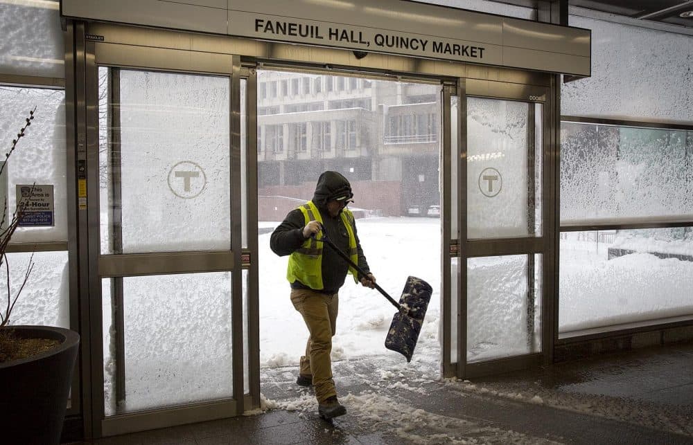 Staff worked to keep entrances clear of snow at the MBTA's Government Center Station. (Robin Lubbock/WBUR)