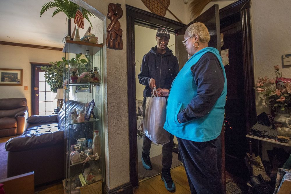Community Servings delivery coordinator and driver Lee Williams brings weekly meals to Kimberly Scarlett at her home in Dorchester. (Jesse Costa/WBUR)