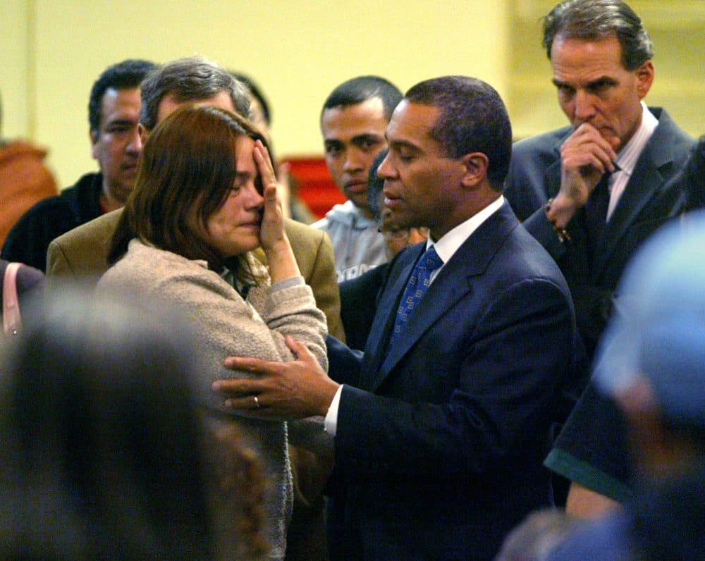 A worker from Michael Bianco Inc., who gave only her first name, Tiadoro, and said she was from Honduras, was comforted by then-Gov. Deval Patrick as he met with workers and their families at a church in New Bedford in the days after the raid. (David Goldman/AP)