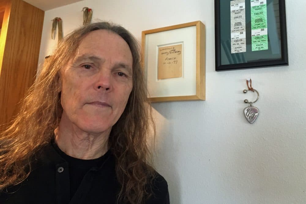 Schmit stands in front of a framed note from Eagles bandmate Glenn Frey. (Robin Young/Here & Now)