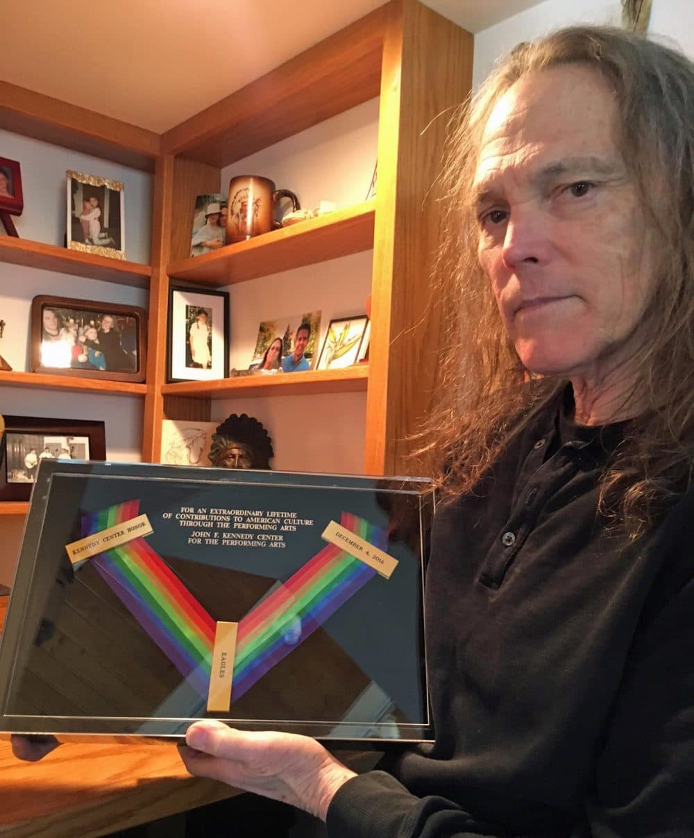 Schmit holds the Kennedy Center Honors medal won posthumously by Eagles bandmate Glenn Frey. (Robin Young/Here & Now)