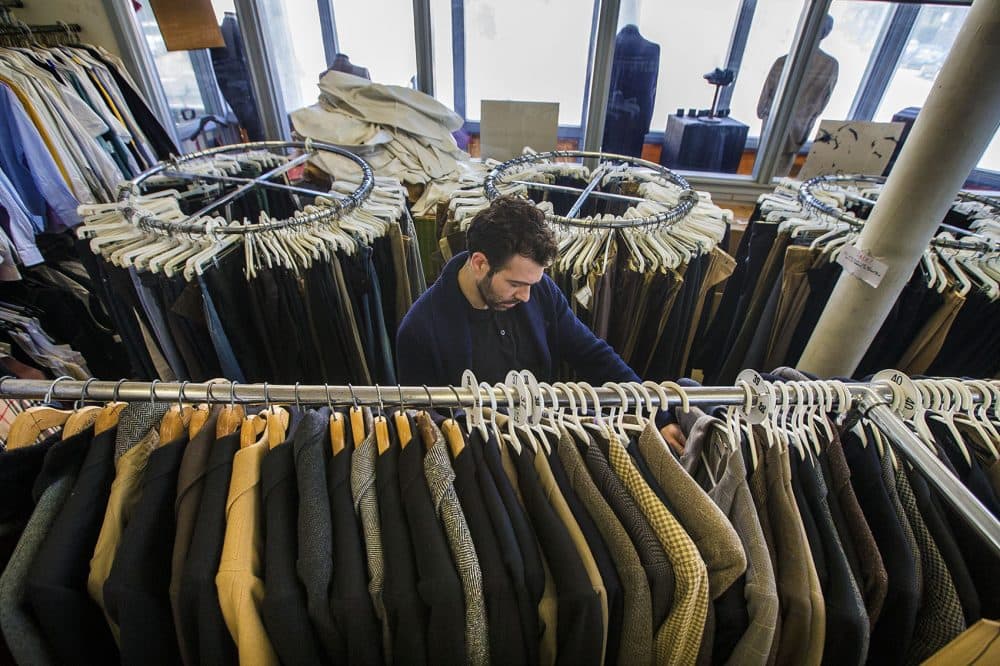 Asa Zabarsky files through a rack of suit jackets at Keezer's. Even though he’s sold the building, owner Len Goldstein has yet to sell the actual business. He's still talking to potential buyers, but says many have been discouraged once he describes how much work is involved. (Jesse Costa/WBUR)