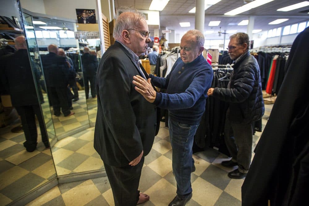 Steve Cauley, of Somerville, gets outfitted by a Keezer's staff member. Keezer’s is classic old-school retail, with cardboard boxes lining the walls inside the entrance and all of the store signs handwritten in marker. (Jesse Costa/WBUR)