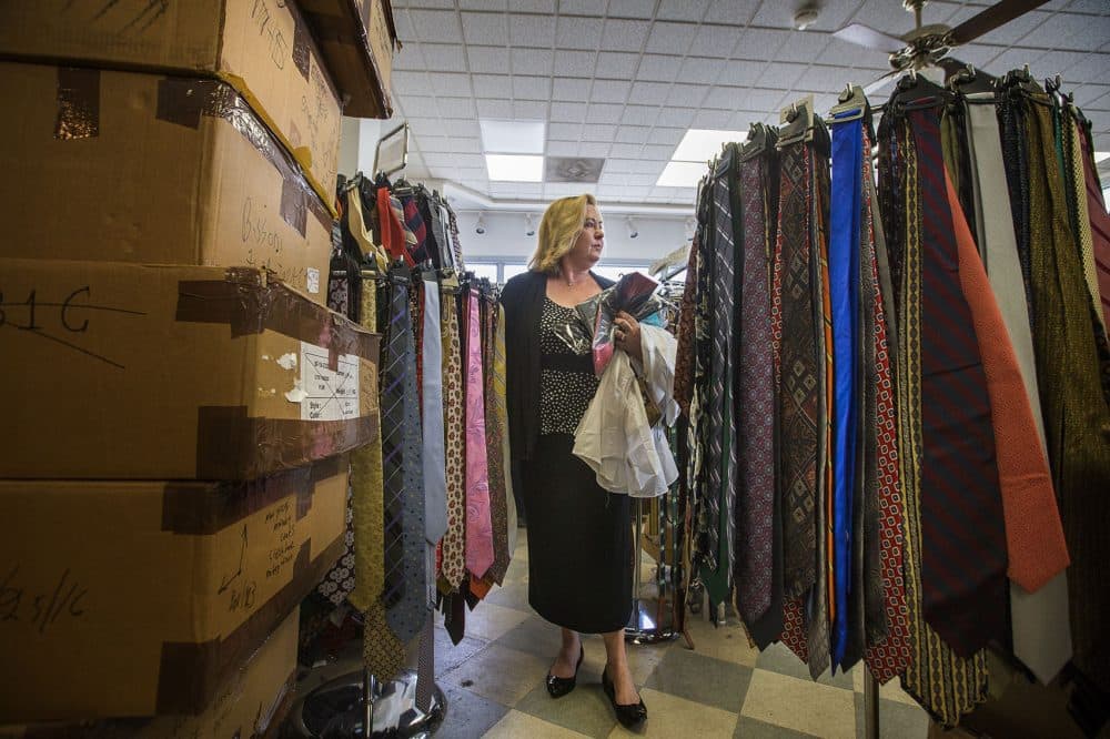 Kathy Seaman makes her way through Keezer's tie racks and piles of boxes looking for formal wear for residents of the senior home where she works in Jamaica Plain. (Jesse Costa/WBUR)