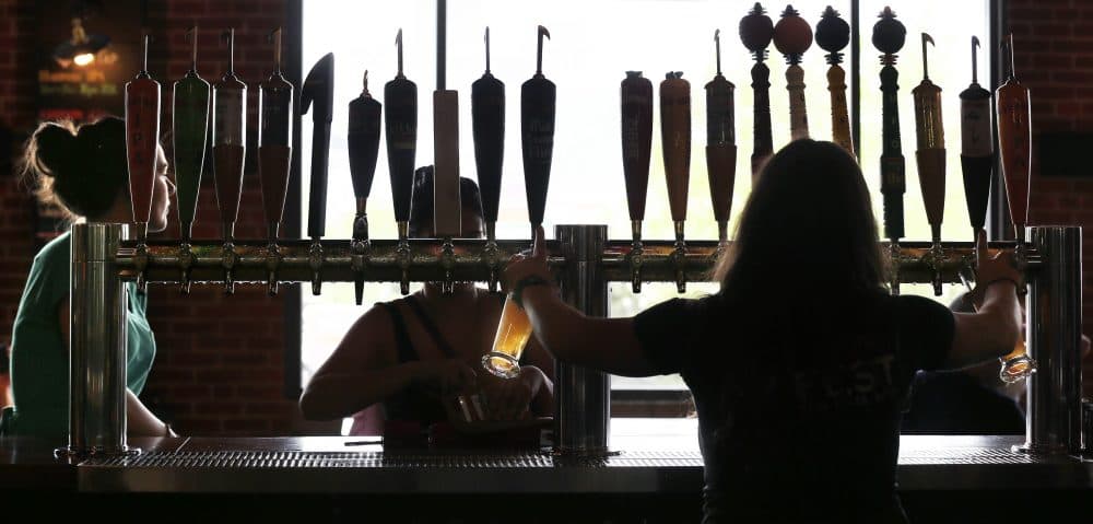 Tom Keane: "It’s time for the Bay State to stop trying to tell liquor businesses how they can compete and simply let them compete." Pictured: A bartender at the Harpoon Brewery in the Seaport District of Boston in 2013. (Charles Krupa/AP)