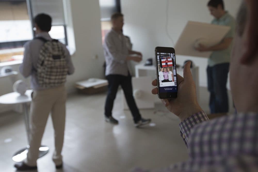 AFFOA CEO Yoel Fink plays a Bruce Springsteen song from the information that is stored in the fabric of a JanSport backpack using the AFFOA Looks app on his smartphone. (Jesse Costa/WBUR)