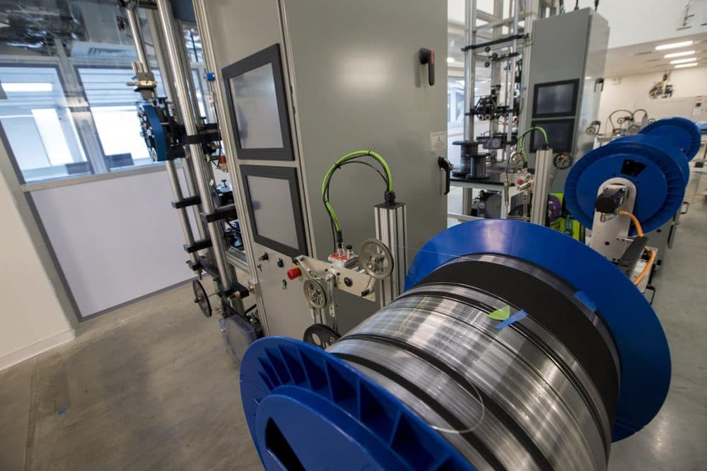 Fiber is spooled from the bottom of two 20-foot-tall draw towers. (Jesse Costa/WBUR)
