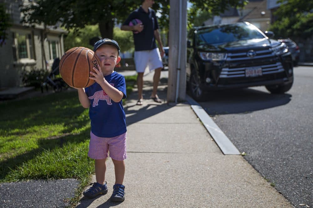 Two-and-a-half-year-old Robbie Klein has hemophelia, a medical condition in which the ability of the blood to clot is reduced. Here Robbie prepares to shoot some hoops with his father, Joel. (Jesse Costa/WBUR)