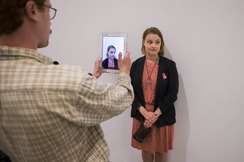 Andrea Goetschius getting her photograph taken for her documentation as part of the interactive "Naturalization Drawing Table." (Jesse Costa/WBUR)