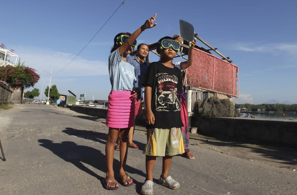 Children wear goggles to watch a solar eclipse in the sky in Indonesia in March 2016. (Firdia Lisnwati/AP)