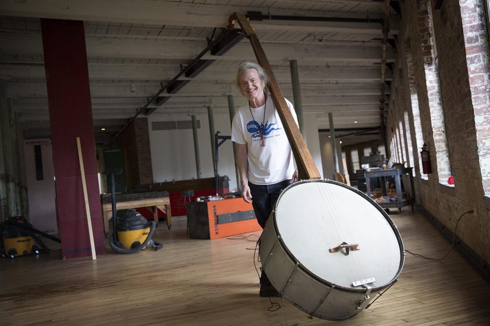 Musician Mark Stewart with Gunnar Schonbeck's giant banjo at MASS MoCA. (Robin Lubbock/WBUR)