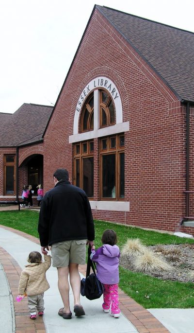A man walks with two children into the Essex Library. (Courtesy Essex Library)