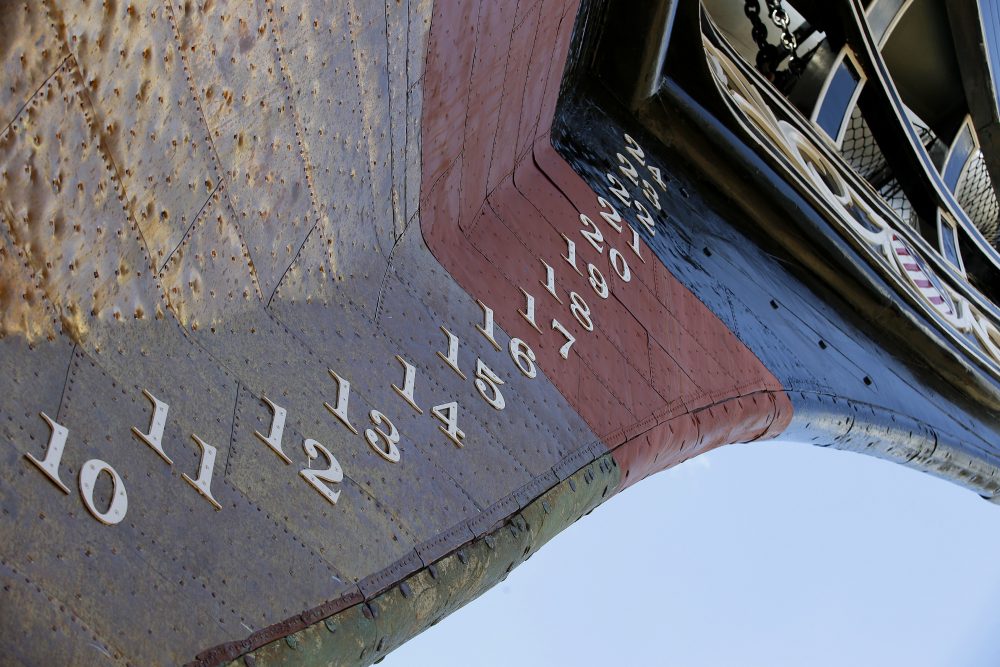 Parts of the USS Constitution's new copper sheathed hull glisten in the sun. (Stephan Savoia/AP)