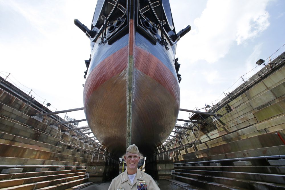 In this July 17 photo, Bob Gerosa, the 74th Commander of USS Constitution, "Old Ironsides," the world's oldest commissioned warship, stands beside the vessel while it sits in dry dock after its restoration. (Stephan Savoia/AP)