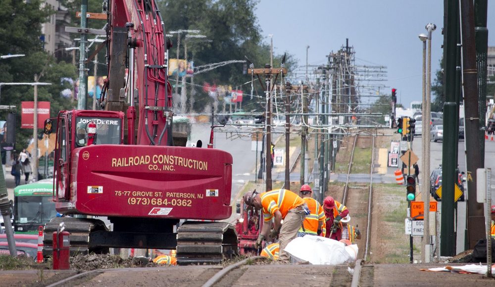 Workers remove MBTA Green Line B branch tracks on Commonwealth Avenue on Thursday, as part of the bridge replacement. The Peter Pan buses, at left, are shuttling MBTA riders. (Kathleen Dubos for WBUR)
