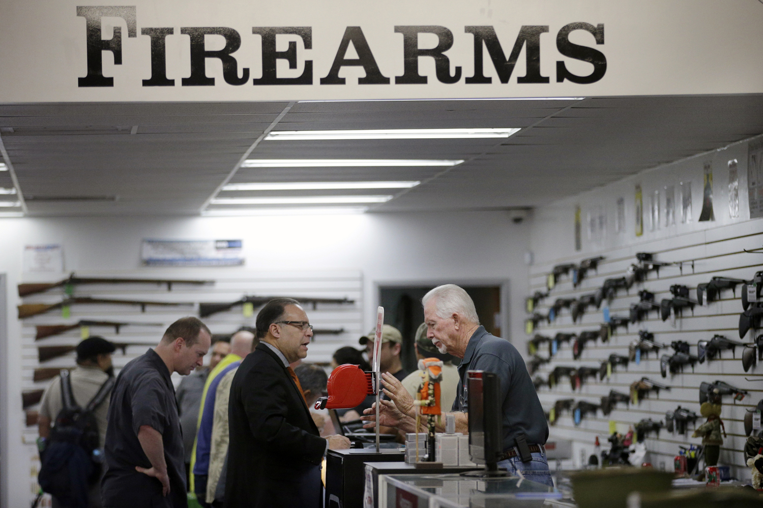 In this Dec. 9, 2015, photo, sales associate Mike Conway, right, shows Paul Angulo guns at Bullseye Sport gun shop in Riverside, Calif. (Jae C. Hong/AP)