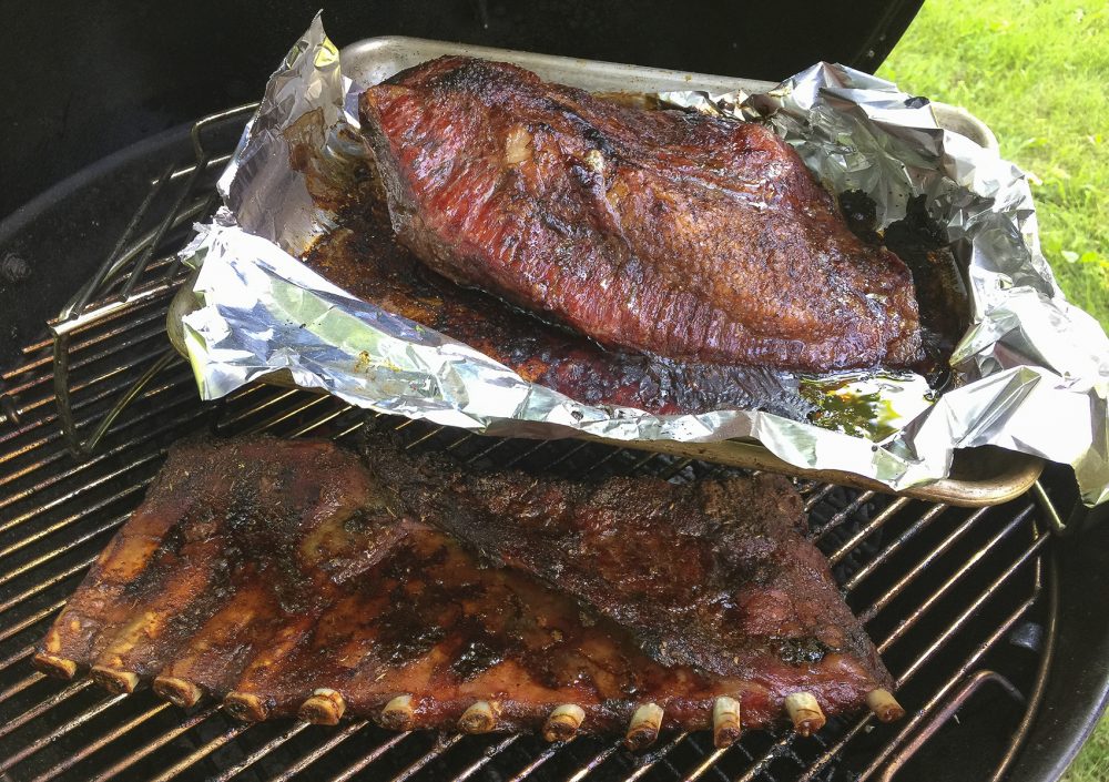 Kathy's Texas-style brisket (top) and dry-rubbed pork ribs on the grill. (Kathy Gunst for Here & Now)