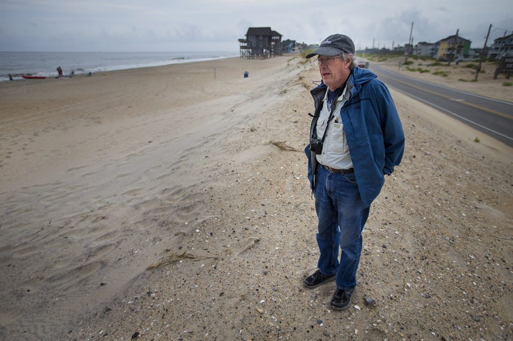 Stanley Riggs, de la Universitatea din Carolina de Est, se află la marginea plajei Rodanthe și a autostrăzii 12. (Jesse Costa/WBUR)