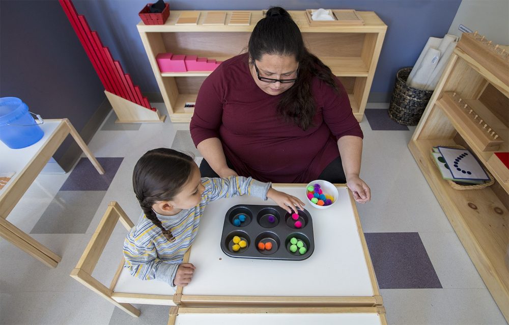 Linguist and teacher Tia Pocknett plays a color matching game with a young student. She calls out the Wampanoag names of colors as the student as she is matching the colored balls. (Jesse Costa/WBUR)