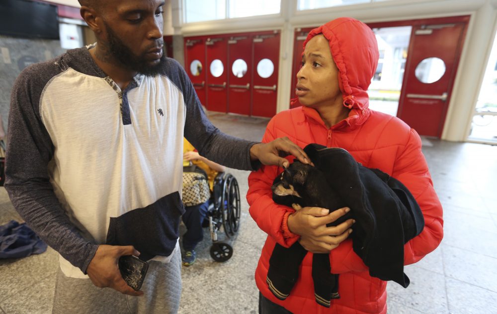 Brandon Spears, left, checks on his wife D'Ona Spears and her dog, Missy, at a shelter for flood evacuees in the convention center in Houston. Spears and her family walked to the shelter after her home was flooded with water from the Buffalo Bayou. (LM Otero/AP)