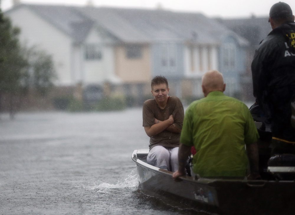 Members of the Louisiana Department of Wildlife and Fisheries and the Houston Fire Department rescue residents stranded from floodwaters from Harvey on, Monday. (Gerald Herbert/AP)