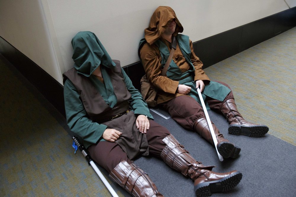 Cody Nickerson, left, and Baxter Mattes, both of Marshfield, take a break dressed as Star Wars Jedi. (Michael Dwyer/AP)
