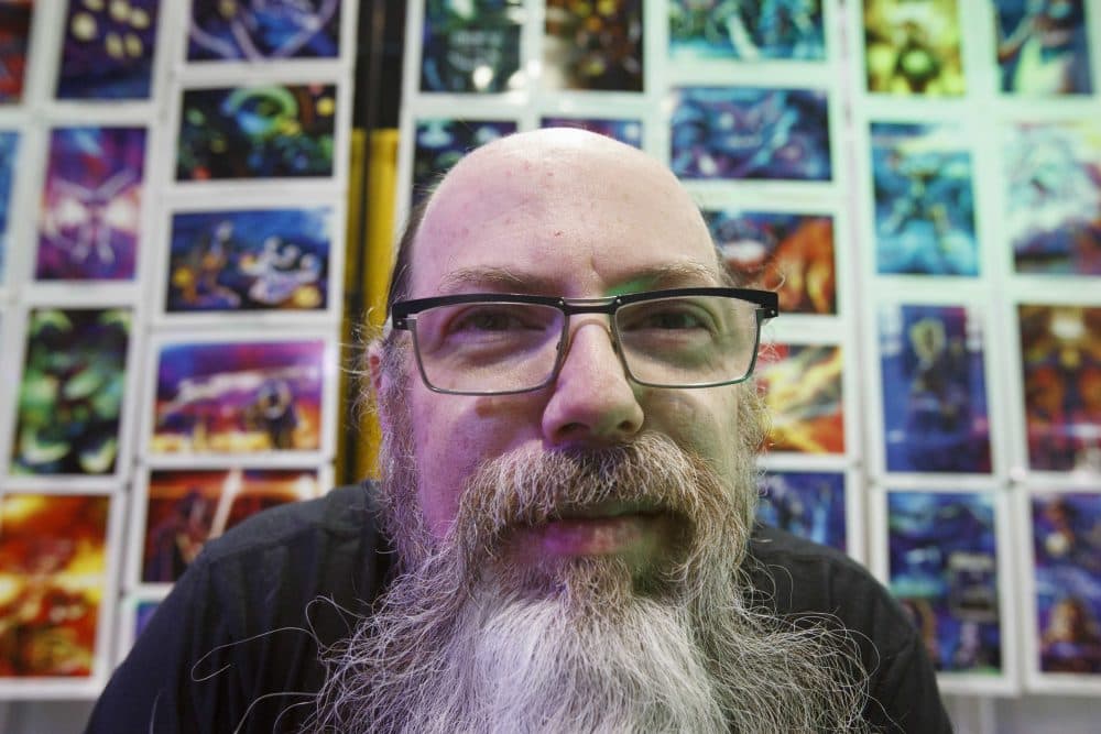 Artist Jerry Pesce poses in front of a wall of his art in his booth. (Michael Dwyer/AP)